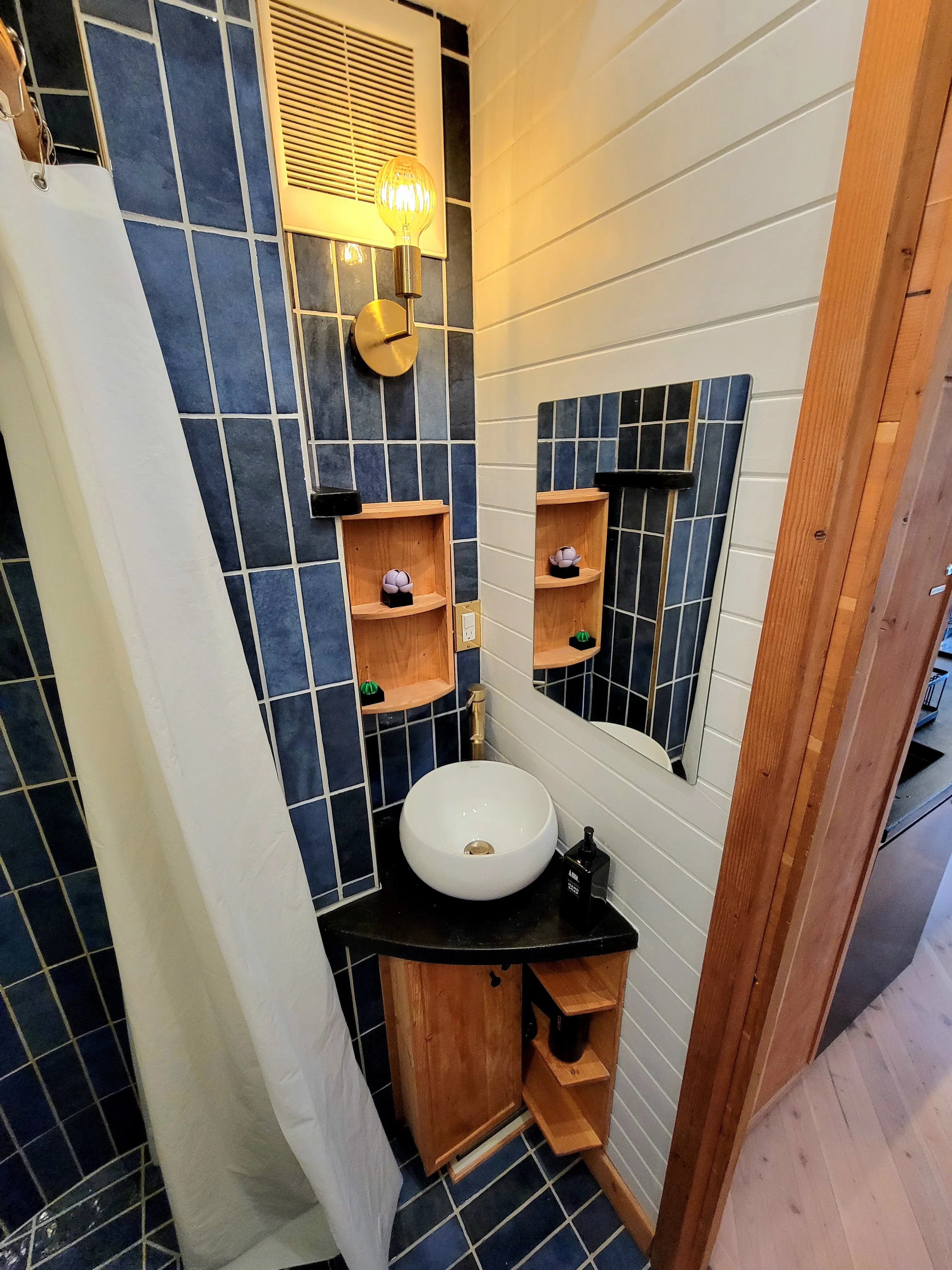 Bathroom with Blue Tile and Wood Finishes
